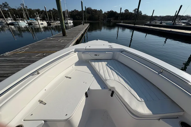 Slide: The Image of 2014 Sea Hunt Triton 225 boat docked at marina, featuring spacious seating area. - 12