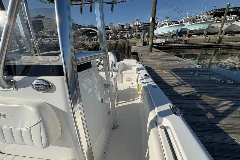 Slide: The Image of 2014 Sea Hunt Triton 225 boat docked at marina, showcasing sleek design and spacious interior. - 15