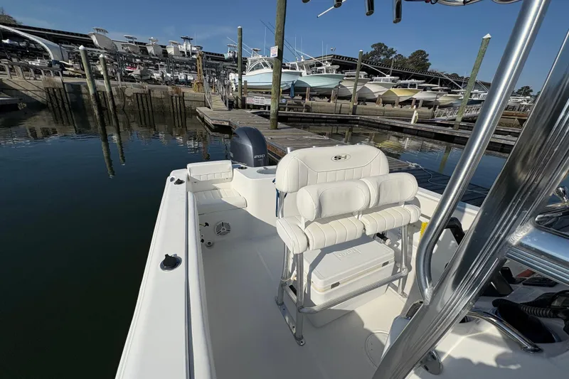 Slide: The Image of 2014 Sea Hunt Triton 225 boat docked at marina, featuring comfortable seating and outboard motor. - 18