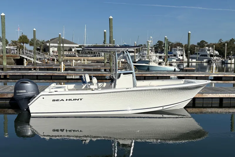 Slide: The Image of 2014 Sea Hunt Triton 225 boat docked at marina with Yamaha engine. - 2