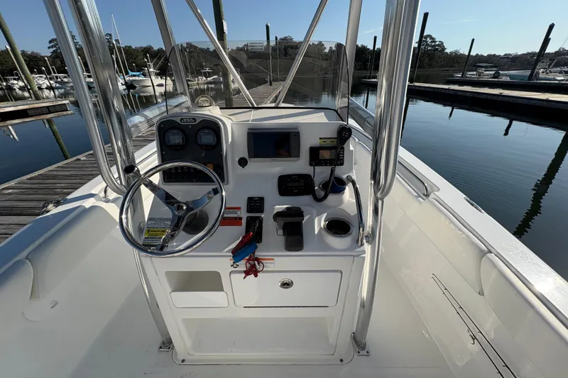 Slide: The Image of 2014 Sea Hunt Triton 225 boat dashboard with steering wheel and controls at marina. - 23