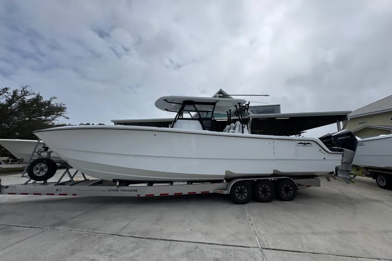 The Image of 2026 Invincible 36 Catamaran on trailer, parked outdoors under cloudy sky. - 1
