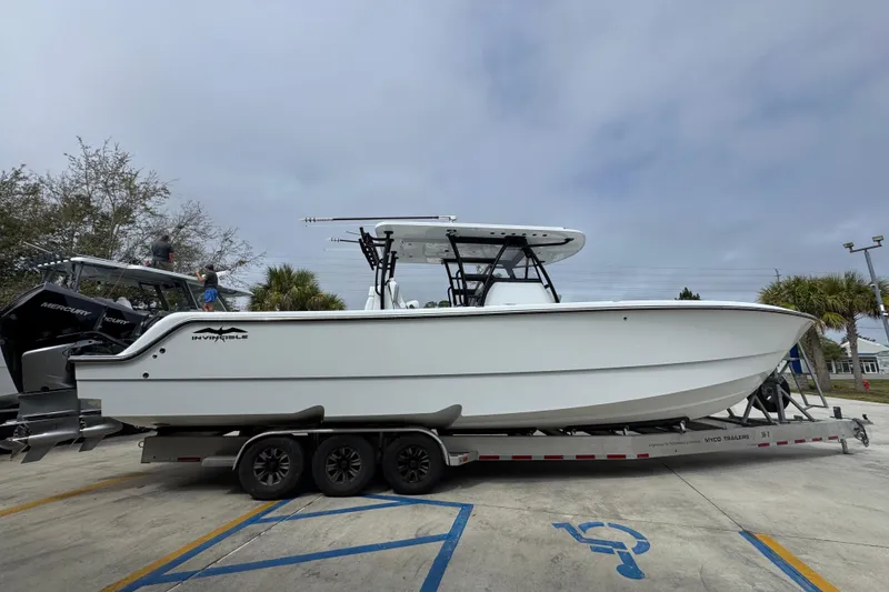 Slide: The Image of 2026 Invincible 36 Catamaran on trailer, side view, parked outdoors. - 10