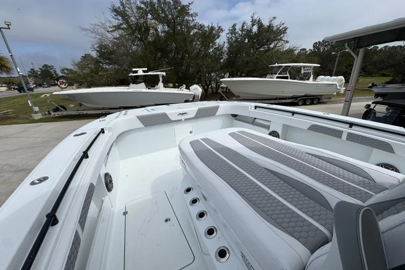 Slide: The Image of 2026 Invincible 36 Catamaran with sleek seating, docked alongside other boats. - 19