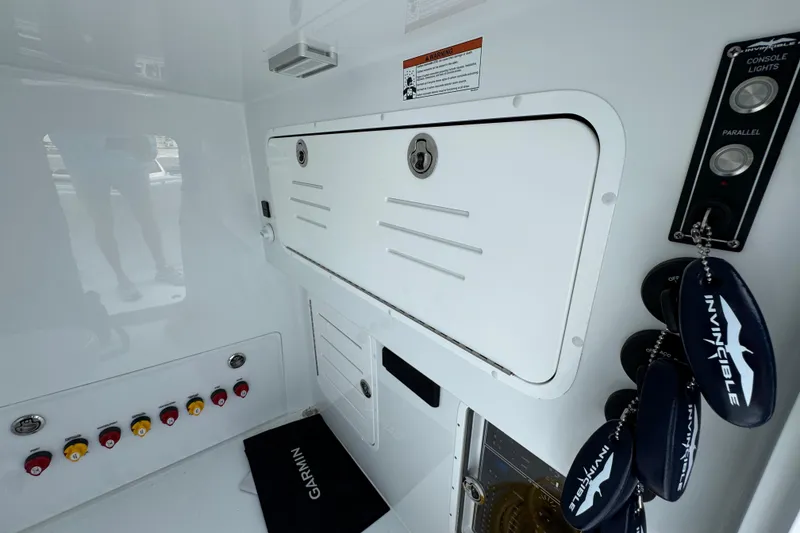 Slide: The Image of Control panel of 2026 Invincible 36 Catamaran with switches and branded keychains. - 25