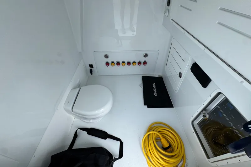 Slide: The Image of Interior of 2026 Invincible 36 Catamaran featuring toilet, control panel, and storage. - 26