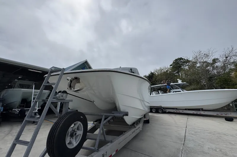 Slide: The Image of 2026 Invincible 36 Catamaran on trailer, parked outdoors under cloudy sky. - 5