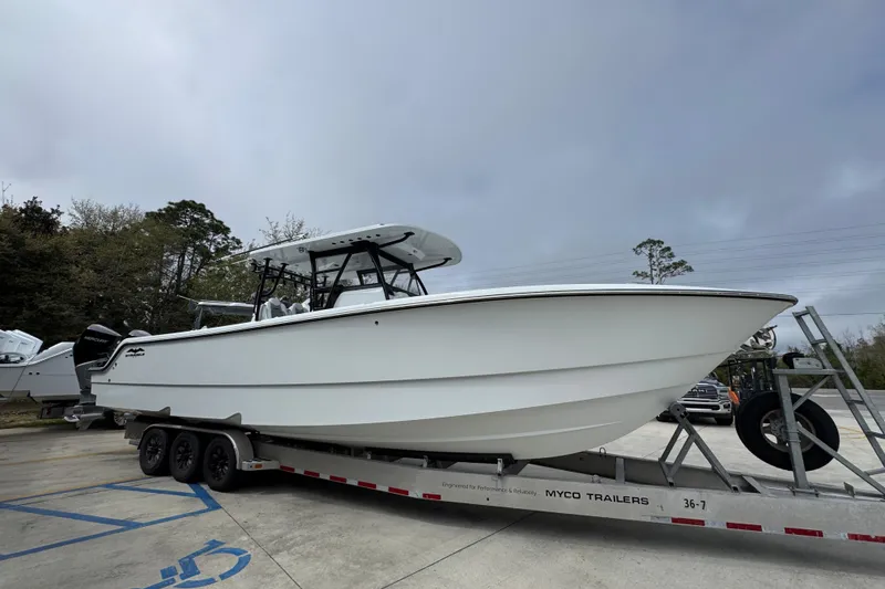 Slide: The Image of 2026 Invincible 36 Catamaran on trailer, parked outdoors under cloudy sky. - 9