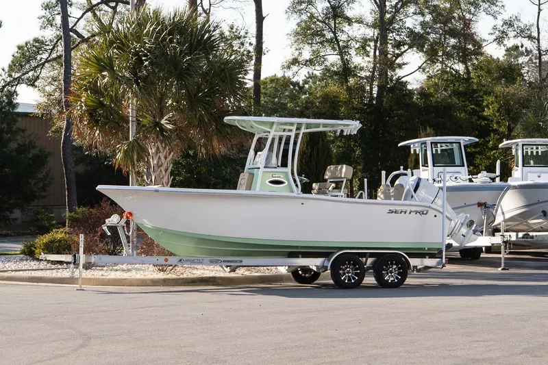 The Image of 2026 Sea Pro 225FLXR Sandbar boat on trailer, parked near palm trees. - 1