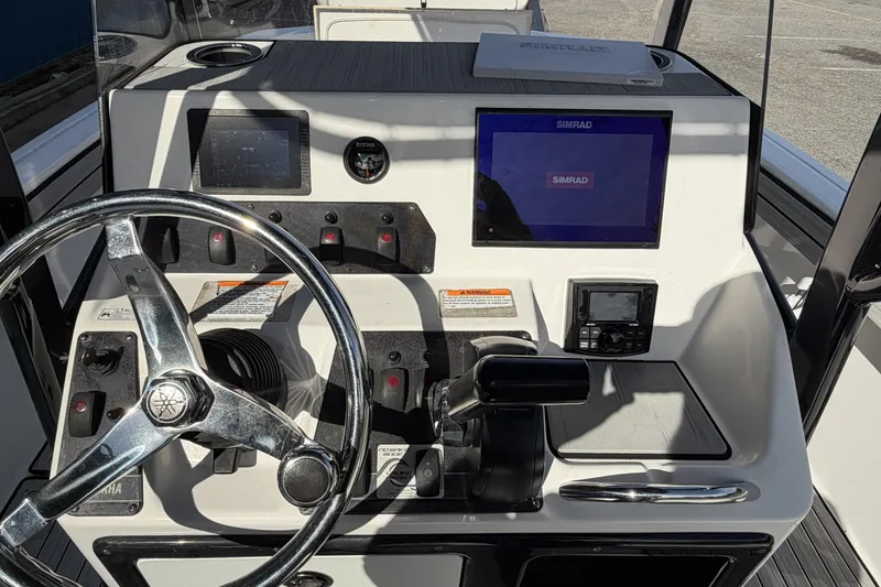 Slide: The Image of 2021 Yamaha Boats 195 FSH Sport dashboard with steering wheel and Simrad display. - 11