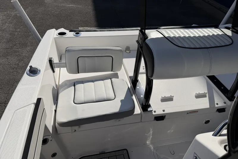 Slide: The Image of 2021 Yamaha Boats 195 FSH Sport interior seating, featuring white cushioned seats and sleek design. - 14