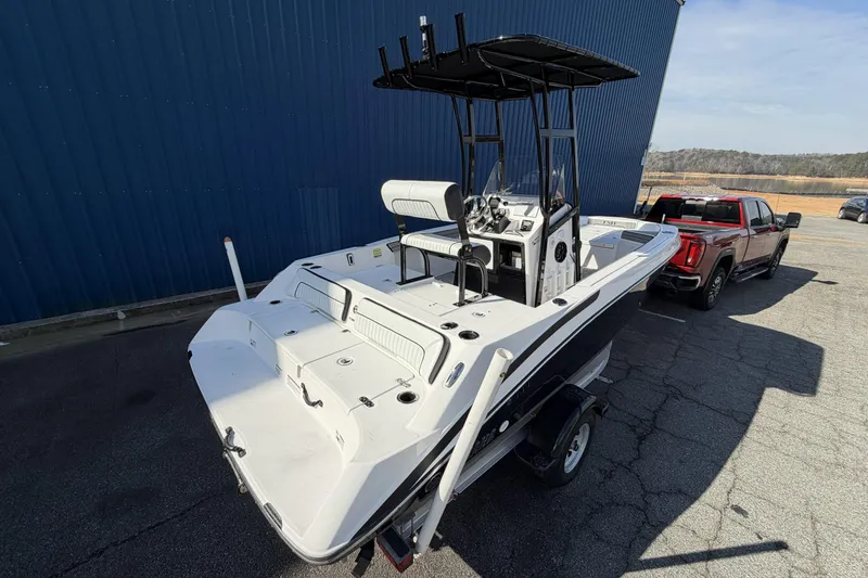 Slide: The Image of 2021 Yamaha Boats 195 FSH Sport on trailer, parked beside a red truck. - 3