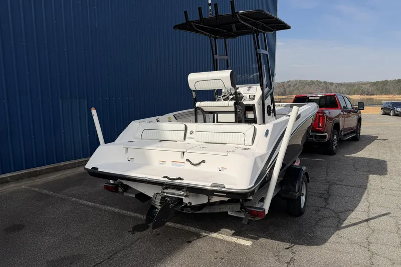 Slide: The Image of 2021 Yamaha Boats 195 FSH Sport on trailer, parked near blue building. - 4