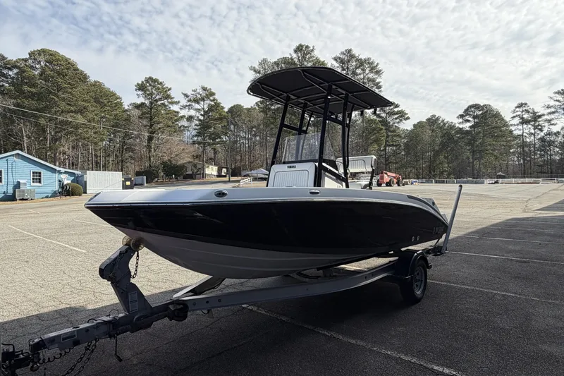 Slide: The Image of 2021 Yamaha Boats 195 FSH Sport on trailer in parking lot, surrounded by trees. - 7