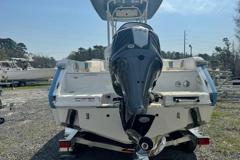 Slide: The Image of 2026 Robalo R232 Explorer boat with powerful outboard motor, parked on gravel lot. - 3