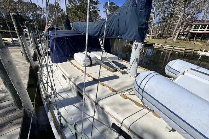 Slide: The Image of 1980 Dickerson Center Cockpit Ketch docked, featuring blue sail cover and inflatable dinghy. - 10
