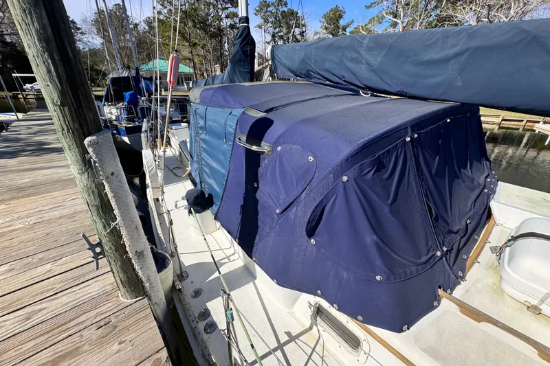 Slide: The Image of 1980 Dickerson Center Cockpit Ketch with blue canvas cover docked at marina. - 11