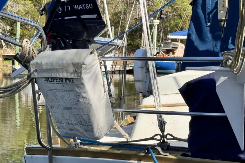 Slide: The Image of 1980 Dickerson Center Cockpit Ketch with Lifesling and Tohatsu motor in marina setting. - 18