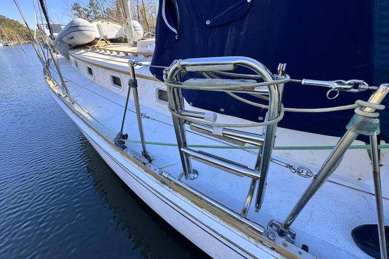 Slide: The Image of 1980 Dickerson Center Cockpit Ketch sailboat with stainless steel fittings docked by the water. - 19