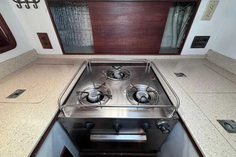 Slide: The Image of 1980 Dickerson Center Cockpit Ketch galley with a three-burner stove and countertop. - 42