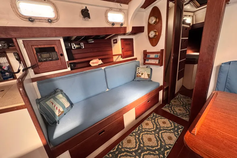 Slide: The Image of 1980 Dickerson Center Cockpit Ketch interior with blue seating, nautical decor, and wood accents. - 46