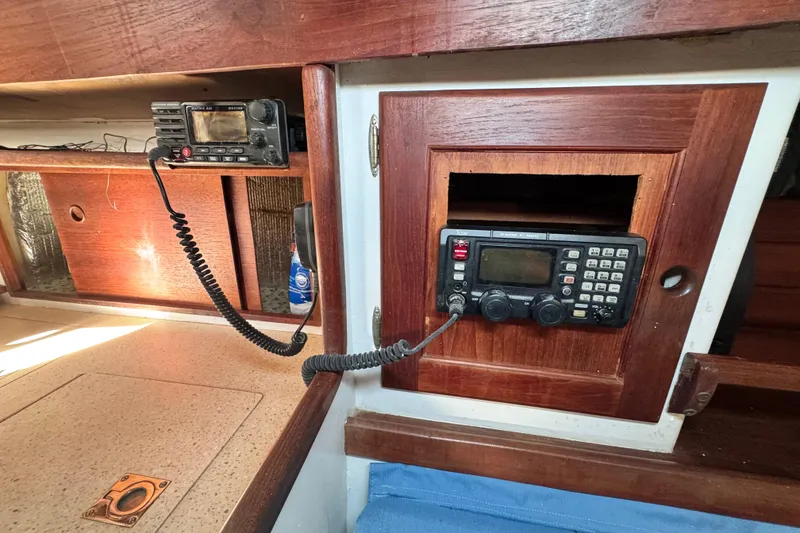 Slide: The Image of 1980 Dickerson Center Cockpit Ketch interior with radio equipment and wooden cabinetry. - 54