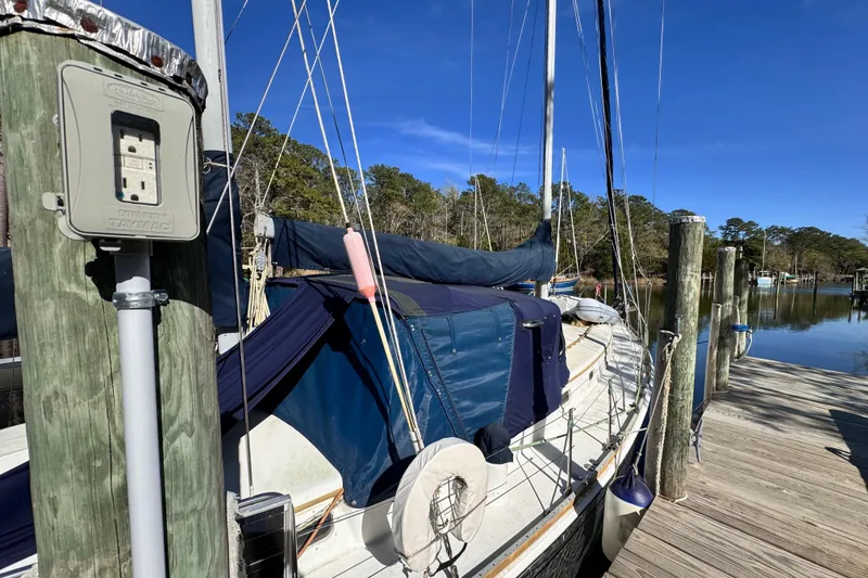 Slide: The Image of 1980 Dickerson Center Cockpit Ketch docked at a serene marina. - 6