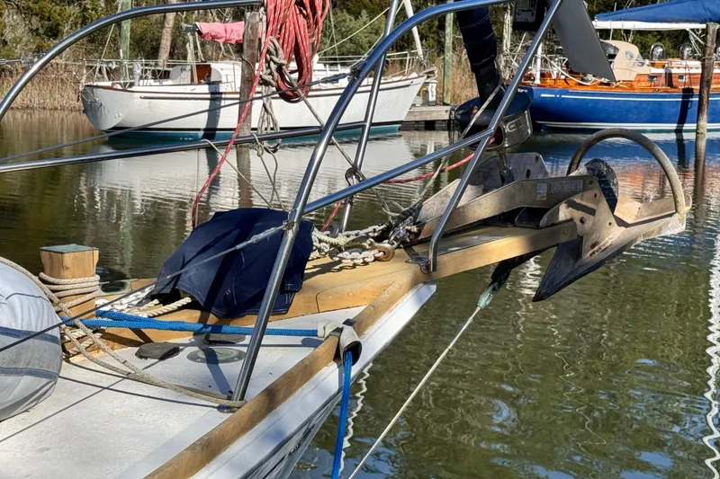 Slide: The Image of 1980 Dickerson Center Cockpit Ketch with anchor, docked in a serene marina setting. - 9