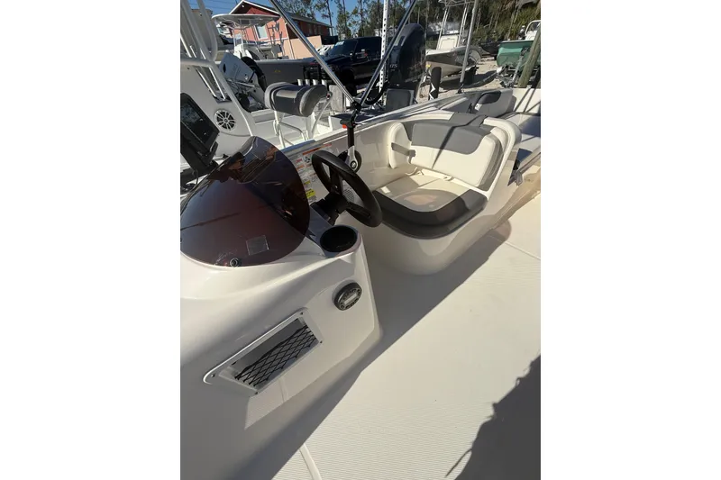 Slide: The Image of 2025 Bayliner Element E18 boat interior with steering wheel and seating area. - 16