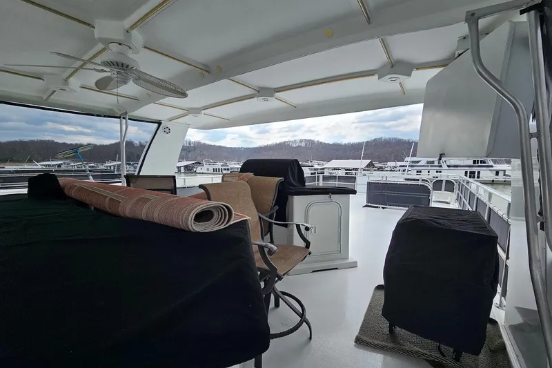 Slide: The Image of Covered deck of 2002 Sharpe 18x85 houseboat with chairs and rolled carpet. - 11