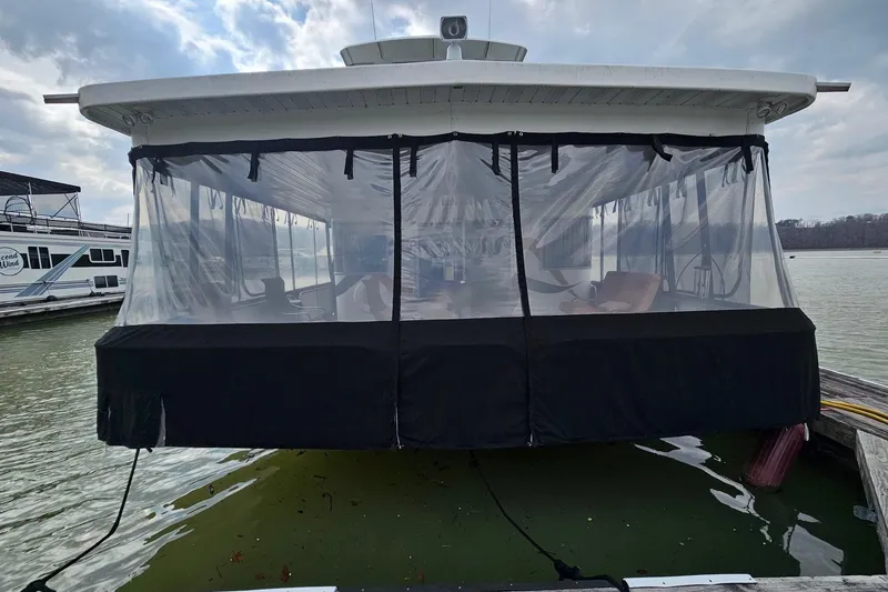 Slide: The Image of Houseboat with clear enclosure, Sharpe 18x85, 2002 model, docked on a calm lake. - 2