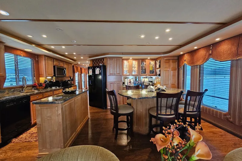 Slide: The Image of Luxurious kitchen interior in a 2002 Sharpe 18x85 houseboat, featuring wood cabinetry and modern appliances. - 23