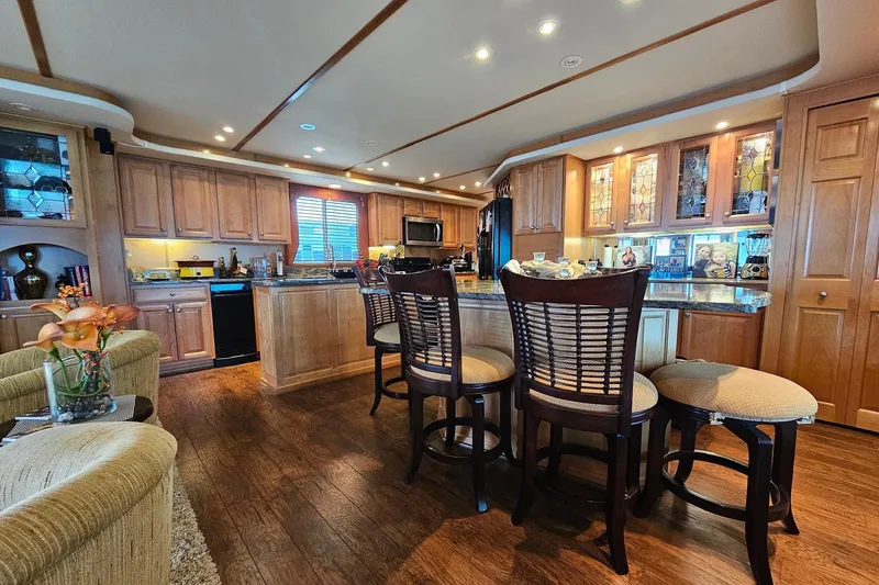 Slide: The Image of Luxurious kitchen interior in a 2002 Sharpe 18x85 houseboat with wooden cabinets and bar stools. - 25