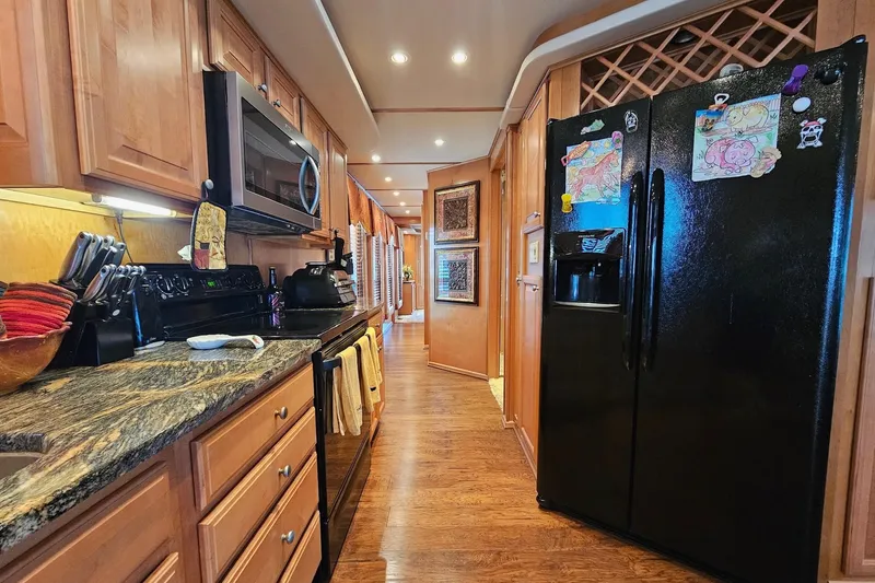 Slide: The Image of Luxurious kitchen in 2002 Sharpe 18x85 houseboat with modern appliances and wooden cabinetry. - 27