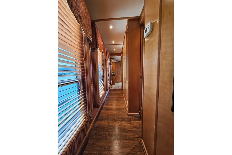 Slide: The Image of Luxurious wooden interior hallway of a 2002 Sharpe 18x85 houseboat with blinds and warm lighting. - 39