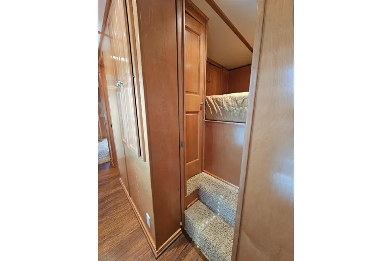 Slide: The Image of Interior of 2002 Sharpe 18x85 houseboat with wooden walls and carpeted stairs. - 40