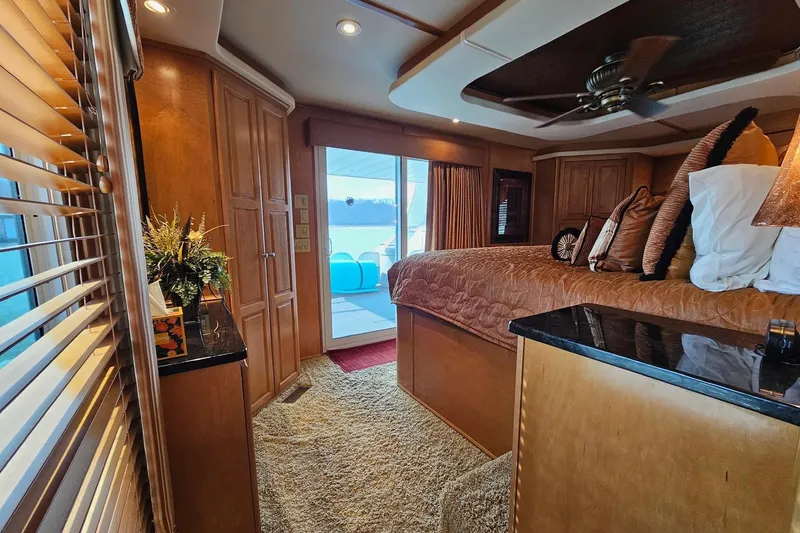 Slide: The Image of Luxurious 2002 Sharpe 18x85 houseboat bedroom with elegant wood finishes and cozy decor. - 49