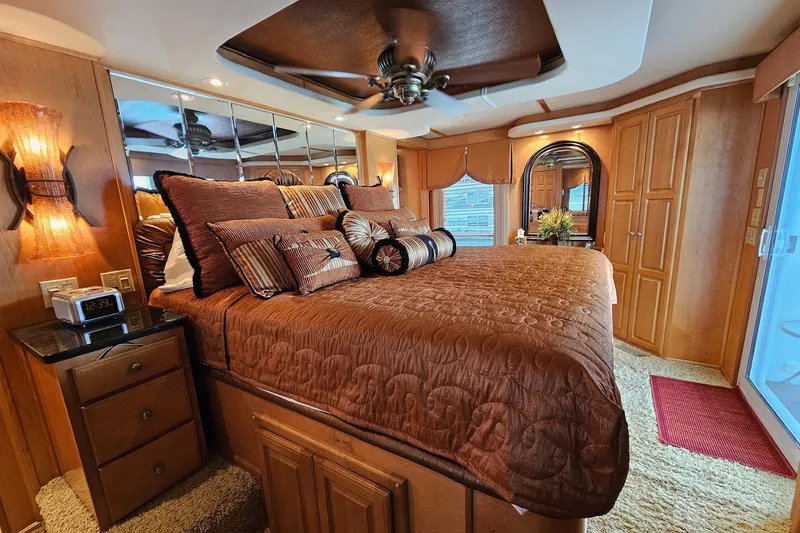 Slide: The Image of Luxurious bedroom interior in a 2002 Sharpe 18x85 houseboat, featuring elegant decor and plush bedding. - 51