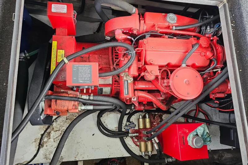 Slide: The Image of Red engine in a 2002 Sharpe 18x85 houseboat, detailed view with cables and components. - 60