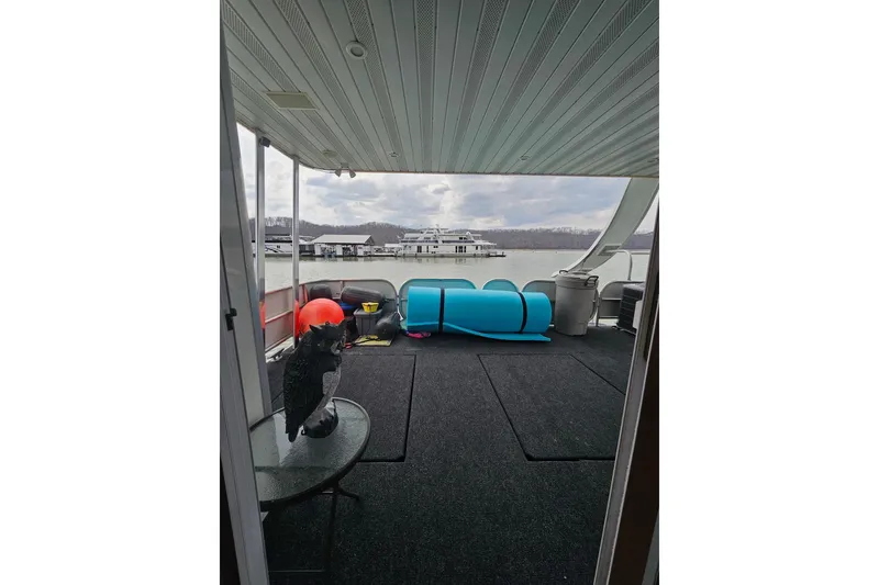 Slide: The Image of Houseboat deck with lake view, featuring outdoor furniture and colorful equipment, Sharpe 18x85, 2002 model. - 61