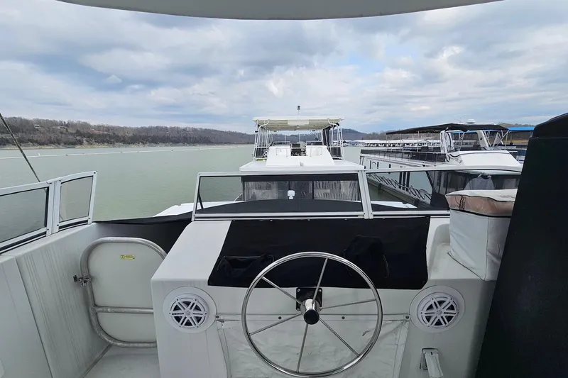 Slide: The Image of 2002 Sharpe 18x85 houseboat helm with lake view and surrounding boats. - 7