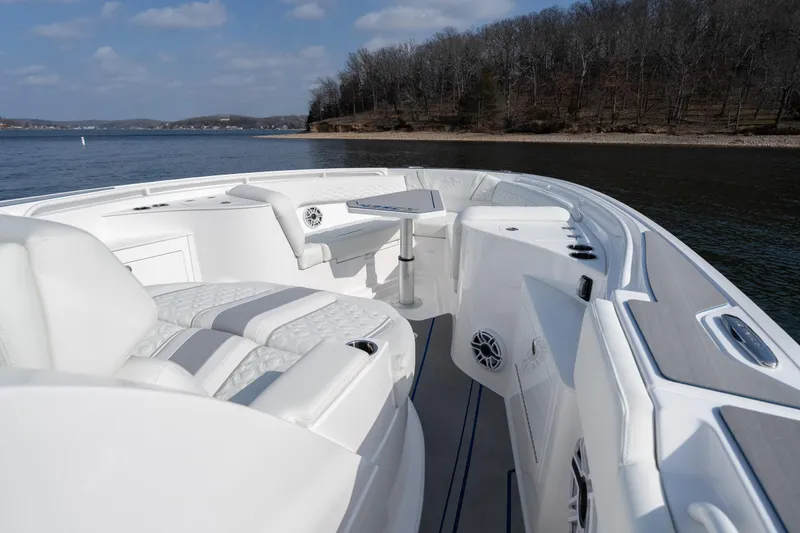 Slide: The Image of 2026 Fountain 43 SCX boat interior with luxurious seating and table on a calm lake. - 11