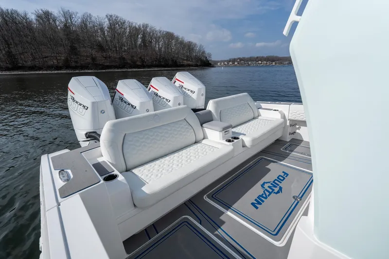 Slide: The Image of 2026 Fountain 43 SCX boat with luxurious seating and powerful outboard engines on a serene lake. - 27