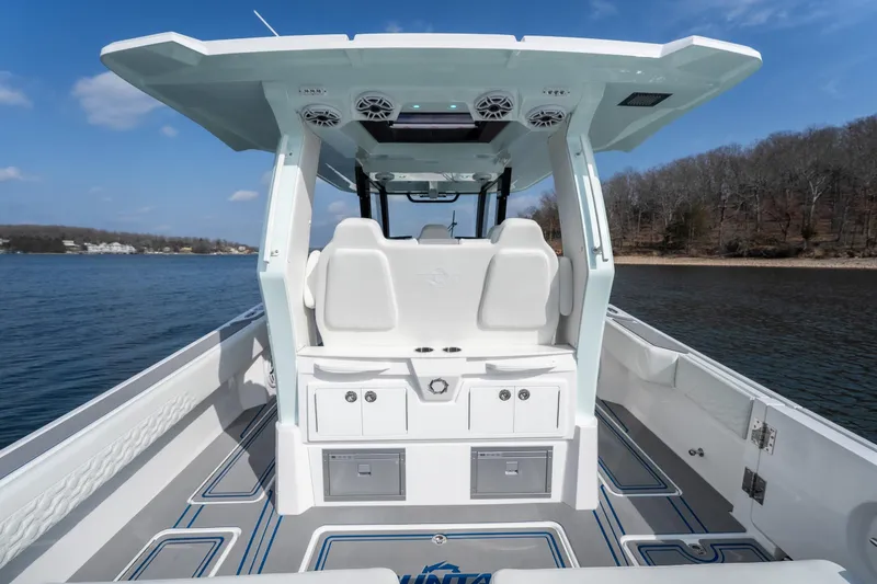 Slide: The Image of 2026 Fountain 43 SCX boat interior, featuring modern seating and sleek design on a calm lake. - 31
