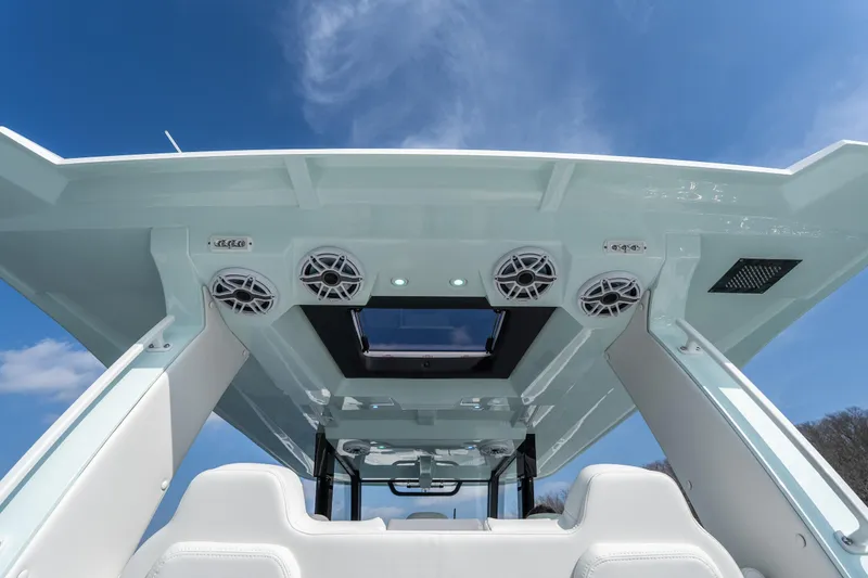 Slide: The Image of 2026 Fountain 43 SCX boat interior with speakers and skylight under a clear blue sky. - 34