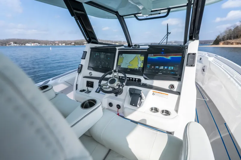 Slide: The Image of 2026 Fountain 43 SCX boat cockpit with advanced navigation displays on a serene lake. - 36