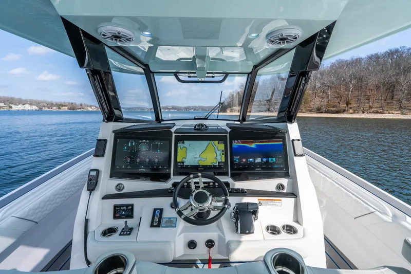 Slide: The Image of 2026 Fountain 43 SCX boat cockpit with advanced navigation systems on a serene lake. - 40
