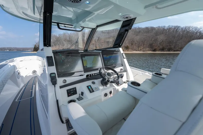 Slide: The Image of 2026 Fountain 43 SCX boat cockpit with advanced navigation systems on a serene lake. - 42