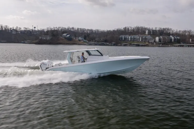 Slide: The Image of 2026 Fountain 43 SCX boat cruising on a lake with scenic shoreline background. - 52