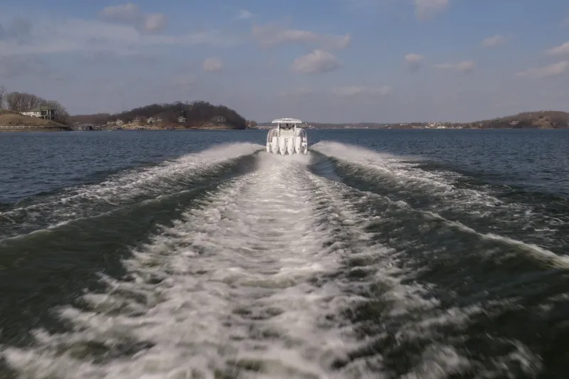 Slide: The Image of 2026 Fountain 43 SCX boat creating waves on a scenic lake. - 55